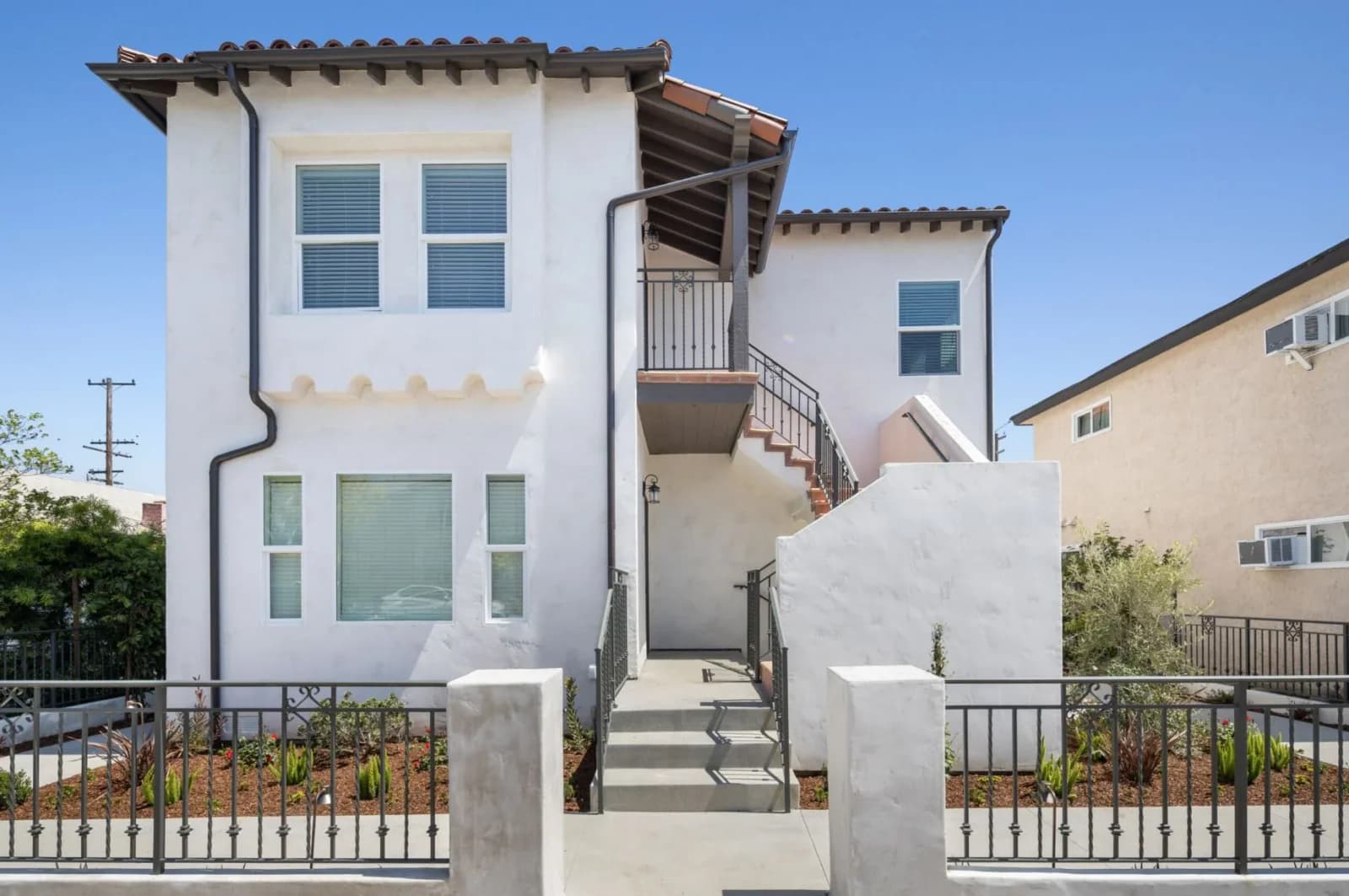 Restored Spanish-style facade of Eastside Lofts with tile roof, stucco, and ironwork stairs